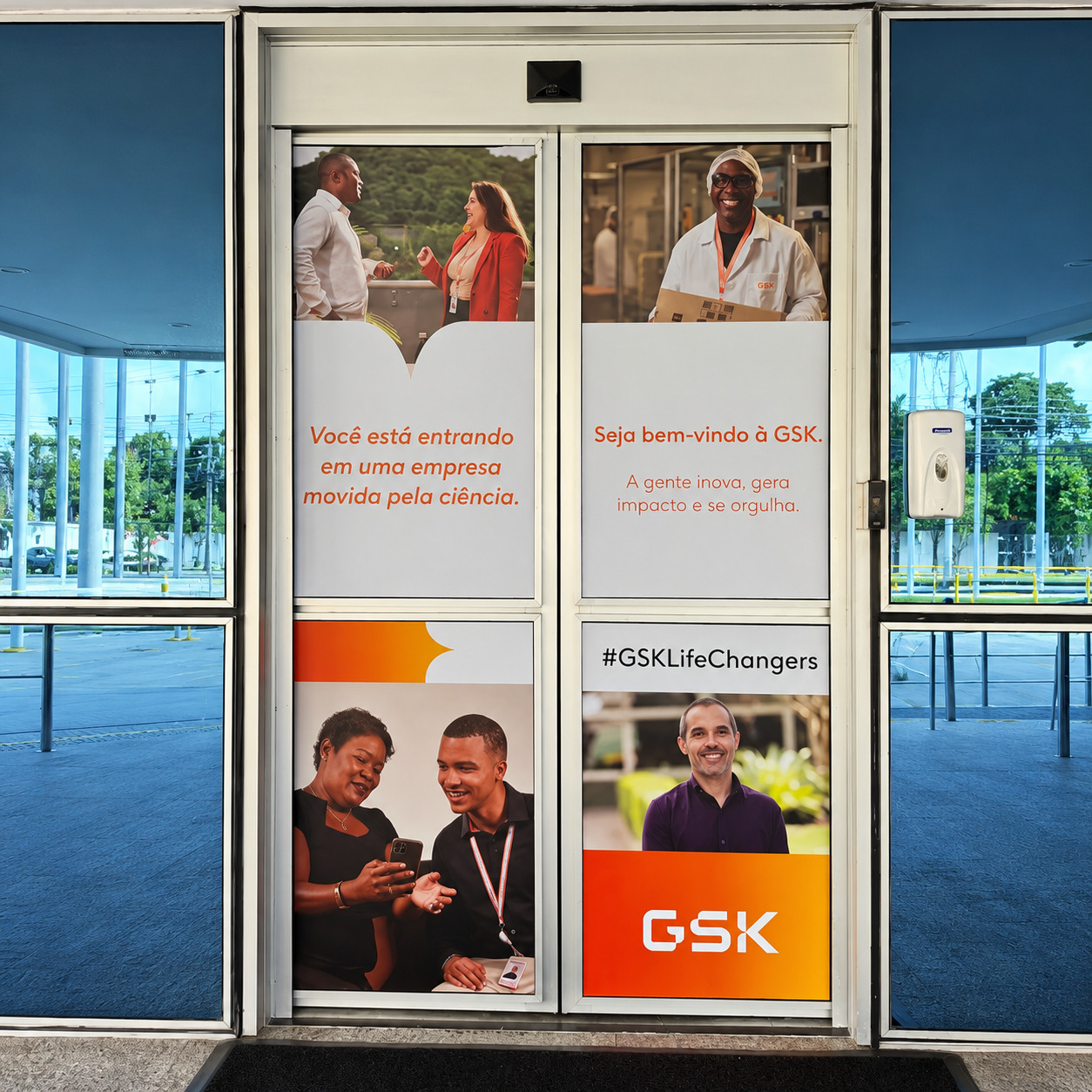 Comunicação visual e envelopamento de portas em ambiente corporativo para a marca GSK.