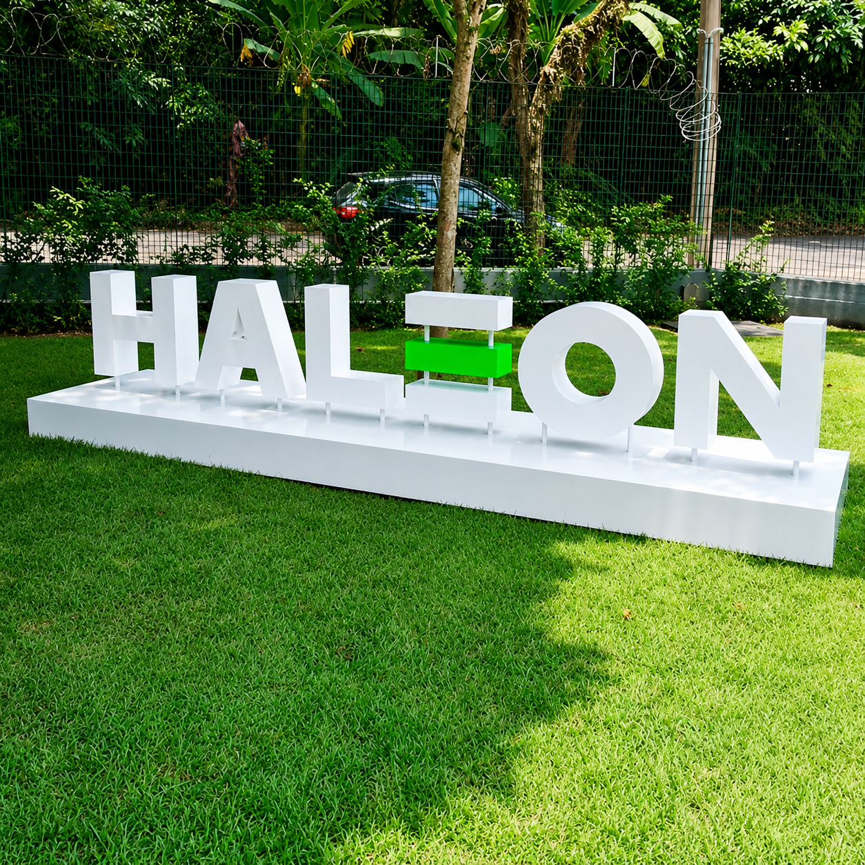 Monumento tridimensional com o logotipo da marca HALEON em letras brancas volumosas, com duas barras verdes centrais
